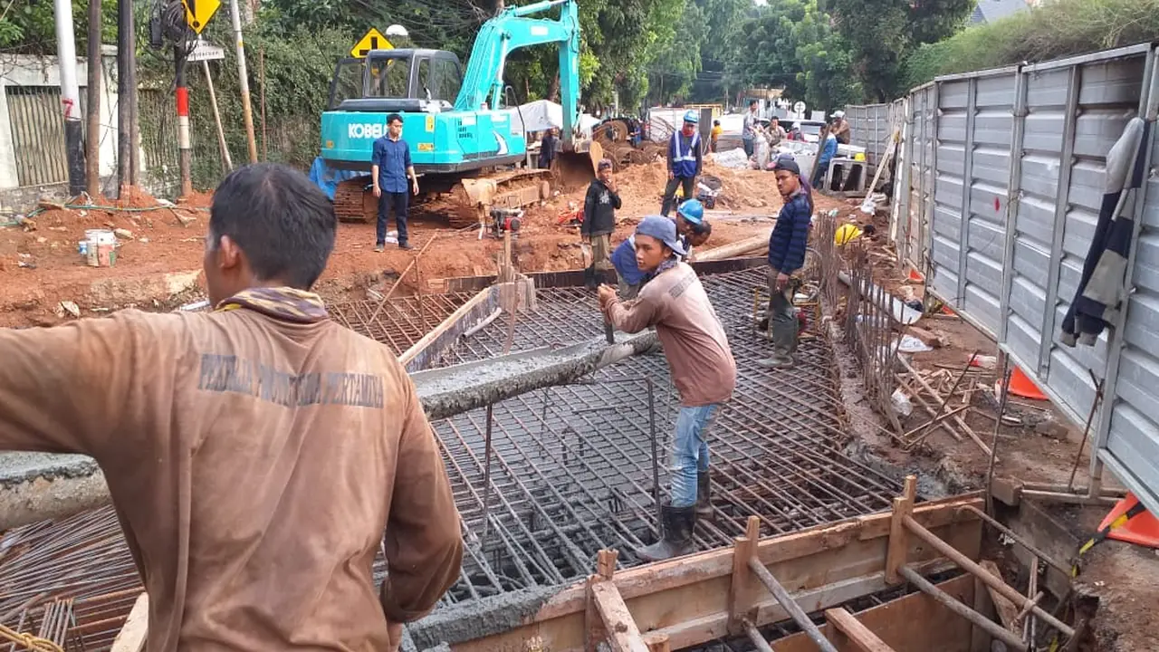 Pekerja merakit tulangan capping beam di sisi galian terowongan, dengan excavator dan pagar pengaman di sekelilingnya
