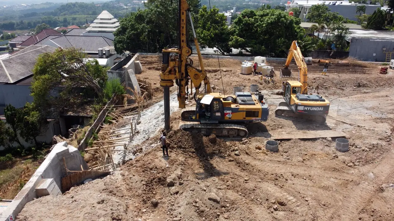 Rig bor bekerja di samping dinding penahan dan permukiman di Bukit Sari, Semarang