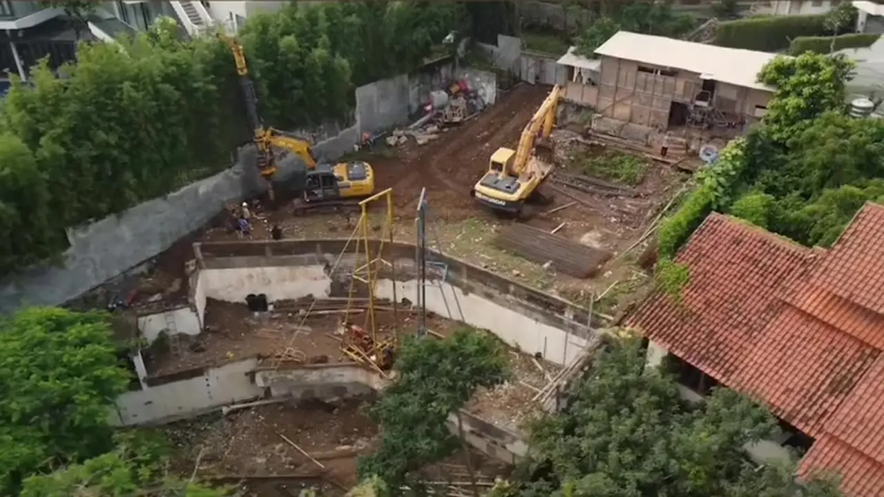 三宝垄 MD Residence 台阶状场地航拍，两台机械在挡土墙与民居之间作业