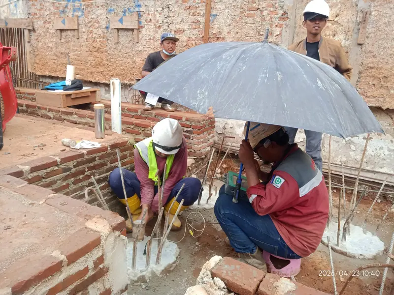 Dua teknisi mengambil data uji integritas tiang di lokasi proyek